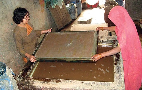 Mahima Mehra, owner of Haathi Chaap paper,
makes a wet sheet from elephant dung slurry
at the manufacturing unit in Jaipur. The sheet is
then sun-dried (Courtesy: Haathi Chaap Paper)
