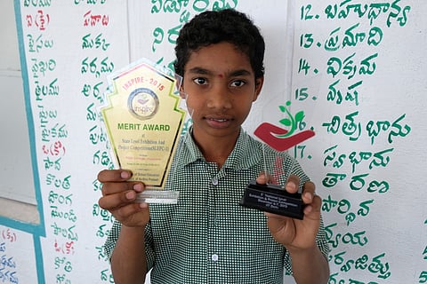 Naveen shows the prizes he won for the clean cooking invention (Credit: CRY)