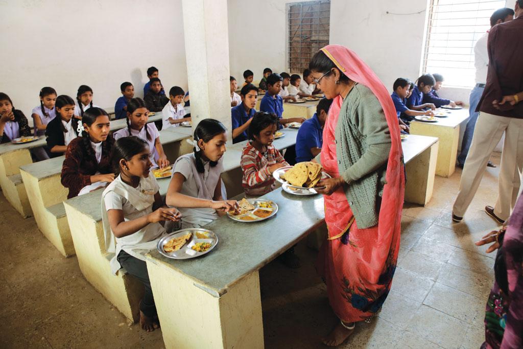 इंदौर के बाहरी इलाके में स्थित एक माध्यमिक विद्यालय में छात्र-छात्राओं को मिड डे मील परोसती एक सहायिका (विकास चौधरी / सीएसई )