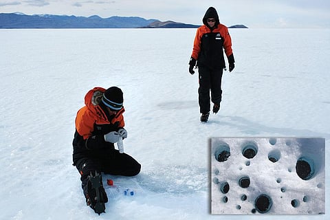 Scientists collecting samples of ice-covered cryoconite holes in Antarctica (inset) a close-up of the dust holes (Courtesy: NERC)
