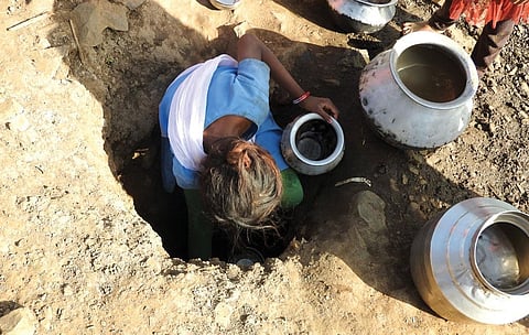 A woman draws water from a ditch in Bajakund village of Madhya Pradesh's Umaria district (Photo: Sachin Kumar Jain)