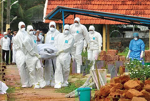 Doctors and relatives wearing protective gear carry the body of a Nipah virus victim, who died on May 24, at a burial ground in Kozhikode, Kerala (Photo: Reuters)