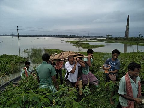 Locals carrying a body of a flood victim in a funeral. Credit: Madhav Bhattacharya