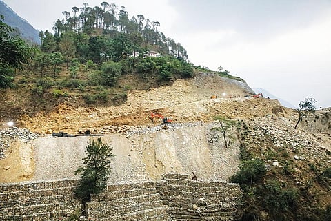 पहाड़ को थामने के लिए बनाई गई कंक्रीट की दीवार यहां कामयाब नहीं है। कीचड़ और छोटे बड़े पत्थर के टुकड़े अक्सर सड़क पर गिर जाते हैं (फोटोग्राफर विकास चौधरी)