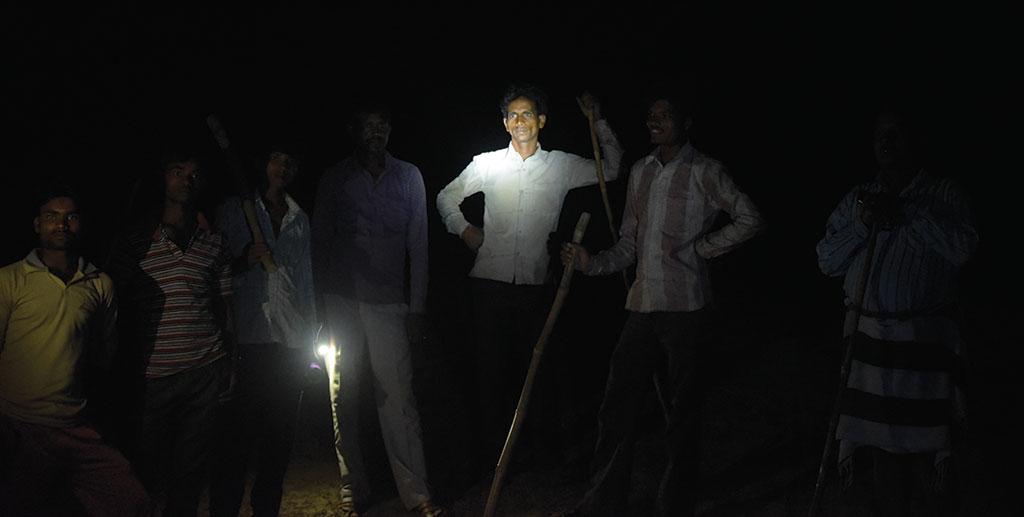 उत्तर प्रदेश के लखीमपुर खीरी जिले के निजामपुर गांव में लोग आवारा मवेशियों से फसलों को बचाने के लिए रातभर जाग रहे हैं। इन्हीं में एक मुकेश (दाएं से तीसरे) मवेशियों के हमले में घायल हो चुके हैं (फोटो: आदित्यन पीसी)