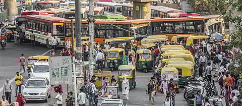 Pedestrians and vehicles on a road in Delhi. Photo: Getty Images