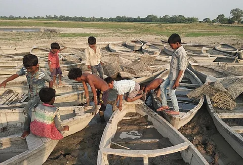 नदी सूखने के बाद खड़ी नावों में खेलते बच्चे। फोटो: पुष्यमित्र