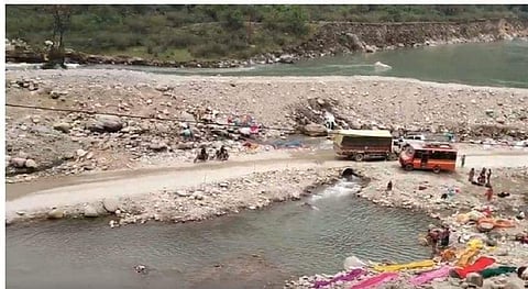 मंदाकिनी नदी पर मलबा डाल कर बनाई गई सड़क से गुजरते वाहन। फोटो: त्रिलोचन भट्ट