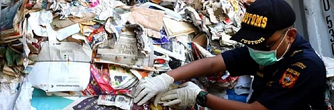 An Indonesian official sifts through hazardous and plastic waste. Photo: Prigi Arisandi, Ecoton