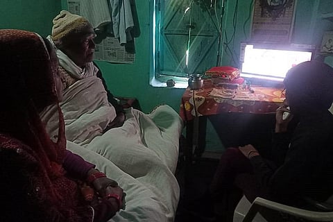 मध्य प्रदेश के रीवा जिले के गांव गांव दुआरी निवासी गुरु रामजी अग्निहोत्री अपने परिवार के साथ बजट देखते हुए। फोटो: निमेश अग्निहोत्री