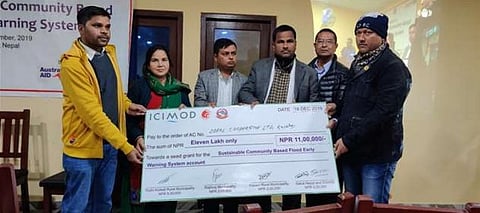 Representatives from three rural municipalities along with Arun Bhakta Shrestha (ICIMOD, second from right) hand over a cheque to the local cooperative Photo: ICIMOD