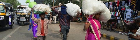 Migrant workers cover their belongings in sacks and carry it on their heads Photo: Arindam Ghosh