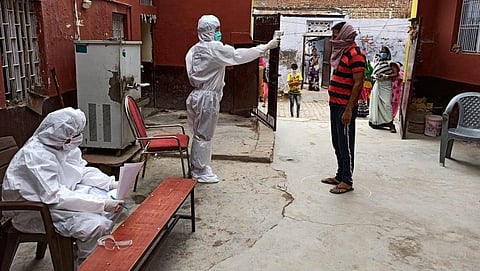 आगरा की एक बस्ती में थर्मल चेकिंग करते स्वास्थ्य कर्मचारी। फोटो: आगरा जिला प्रशासन