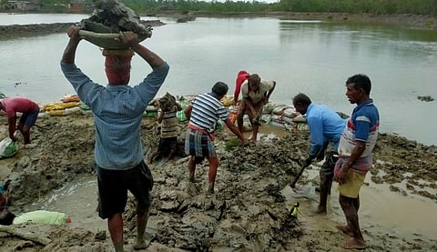 Workers repairing a damaged embankment. Photo: Jayanta Basu