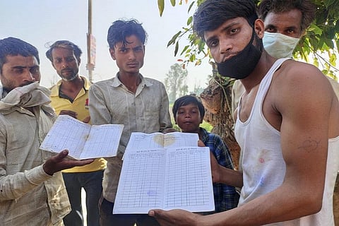 मनरेगा जॉब कार्ड दिखाते गांव के युवा। फोटो: विवेक मिश्रा