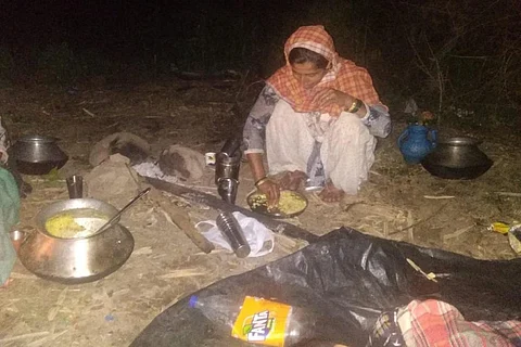 खुले आसमान के नीचे खाना बनाती वन गुर्जर परिवार की महिला। फोटो: रौबिन सिंह चौहान