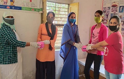 ज़रूरतमंद किशोरियों को नैपकिन बांटती समूह की सदस्या।