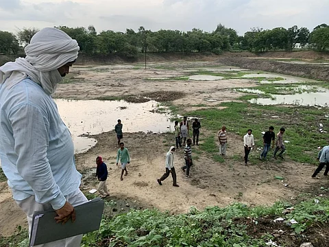 उत्तर प्रदेश के जालौन जिले के गांव धमना में मनरेगा के काम से लौटे लोग।