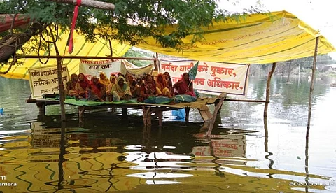 पानी के बीच अनशन करती महिलाएं। फोटो: एनबीए