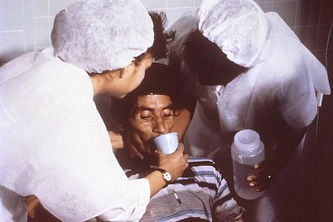 This cholera patient is drinking oral rehydration solution (ORS) in order to counteract his cholera-induced dehydration.