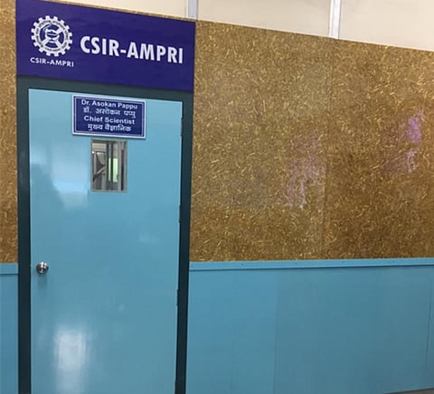 Demo architectural cladding wall in AMPRI, Bhopal. The yellow board is made of Parali (rice straw); the blue board of marble waste. Photo: AMPRI