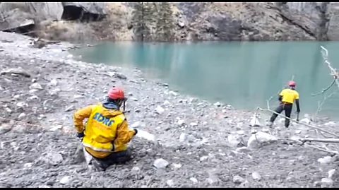 ऋषिगंगा नदी पर बनी झील का आकलन करते एसडीआरएफ के जवान। फोटो: फेसबुक/एसडीआरएफ