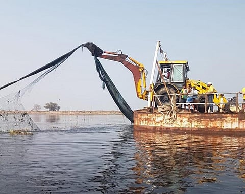 The drive to evict prawn gherries underway at Chilika Lake.