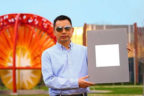 पर्ड्यू यूनिवर्सिटी में मैकेनिकल इंजीनियरिंग के प्रोफेसर शालीन रुआन अब तक के सबसे सफेद पेंट का नमूना प्रदर्शित करते हुए; फोटो: जेरेड पाइक, पर्ड्यू यूनिवर्सिटी