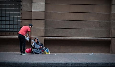 A man offers food to a homeless person in Mexico City: Photo: istock