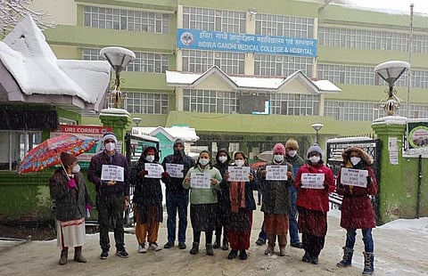 हिमाचल प्रदेश के एनएचएम कर्मचारियों ने प्रदेश के सबसे बड़े अस्पताल में काम बंद रखा और भारी बर्फबारी के बीच में प्रदर्शन किया। फोटो: रोहित पराशर