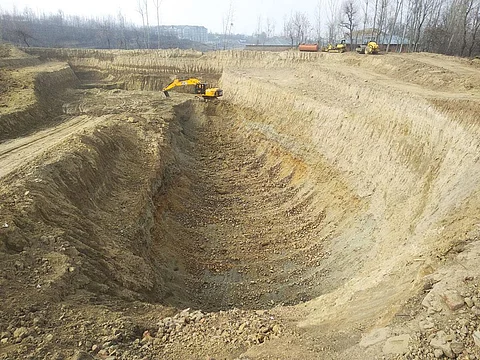 Trucks and earth movers excavate soil from the karewa near Pattan village in Baramulla district for the 58-km-long Srinagar ring road (Photograph: Raja Muzaffar Bhat)