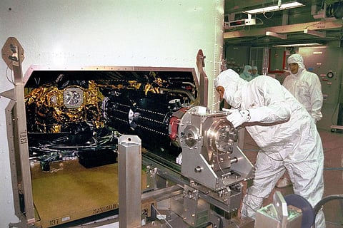 Workers install one of the three Radioisotope Thermoelectric Generators on the Cassini spacecraft launched in October 1997 to study Saturn and its rings