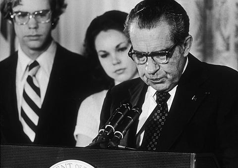 US President Richard Nixon at a White House lectern reading a farewell speech to his staff following his resignation on August 9, 1974