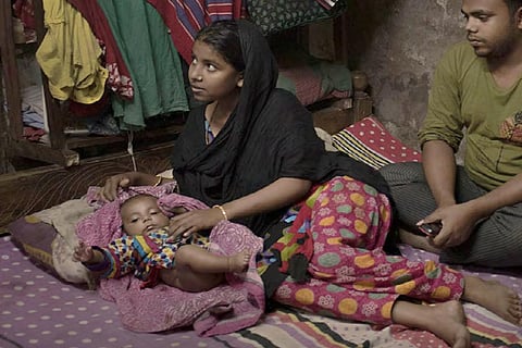 बांग्लादेश में रहने वाली 14 वर्षीय केया अपने 2 महीने के बच्चे रहीम का ध्यान रखते हुए; फोटो: यूएनएफपीए