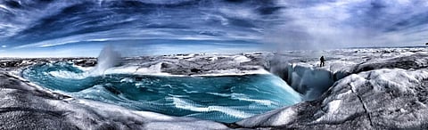 A turbulent melt-river pours a million tons of water a day into a moulin, where it flows through the subglacial environment to ultimately reach the ocean. Photo: Ted Giffords