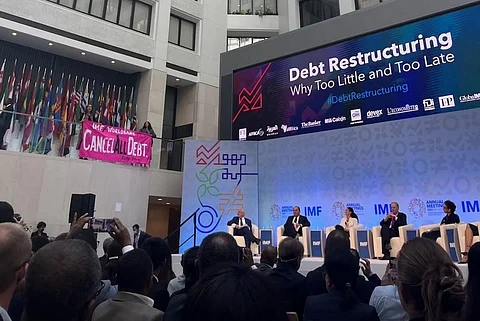 CodePink activists Olivia DiNucci and Nancy Mancias disrupted the panel with a banner asking the institutions to “cancel all debts.” Photo: CodePink