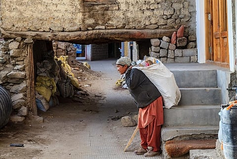 A woman carries a bag of waste in Leh. Photo: iStock