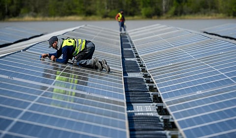 Workers install solar panels for a floating photovoltaic solar plant in Germany in April 2022. Photo by Ina Fassbender / AFP via Getty Images