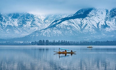 A shikara glides over the Dal lake in the shadow of the Zabarwan Range in Srinagar, Kashmir. Photo: iStock