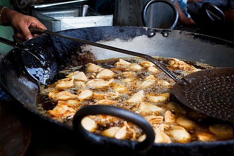 दिल्ली की सड़कों पर ओपन किचन में बनते समोसे: फोटो: आईस्टॉक
