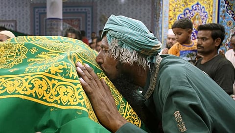 A devotee kisses the 'chadar' at the shrine of Abdullah Shah Ghazi in Karachi. Photo: iStock