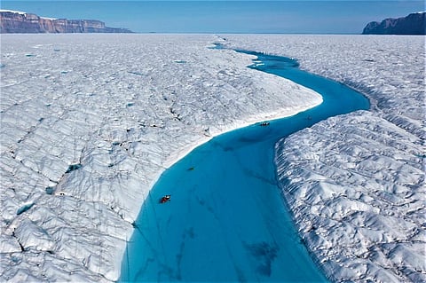 Richard Bates and Alun Hubbard kayak a meltwater stream on Greenland’s Petermann Glacier, towing an ice radar that reveals it’s riddled with fractures. Photo: Nick Cobbing