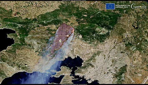 An image Copernicus Sentinel-2 satellites captured July 19, 2023, revealing the burn scar and smoke plume produced by the ongoing Dervenochoria wildfire in western Attica, Greece.
