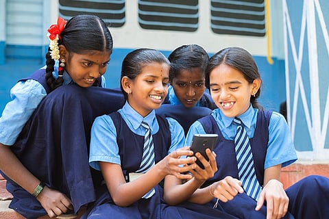 स्मार्टफोन की लत: ब्रेक के दौरान स्कूल में मोबाइल फोन का उपयोग करती बच्चियां; फोटो: आईस्टॉक