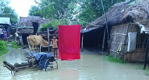 A child stands in front of her flooded house. Photo: Mohd Imran Khan