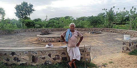 मधासर गांव में खेतों में बने टांके के पास अतिरिक्त पानी को रोकने लिए नाली बनाने वाले रामाराम काम के बीच आराम करते हुए (फोटो: अनिल अश्विनी शर्मा)