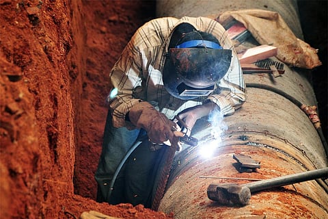 पानी की पाइप को वेल्डिंग करता एक भारतीय श्रमिक; फोटो: आईस्टॉक