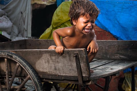 ठेले पर बैठा गरीब, भूखा बच्चा, खाने की करता गुहार; फोटो: आईस्टॉक