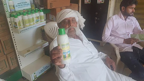 A farmer holds a bottle of nano liquid urea at IFFCO center in Baghpat district, Uttar Pradesh. Photo: Vivek Mishra / CSE