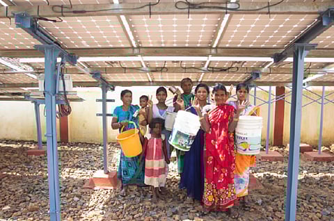 Maligaon villagers stand under the solar microgrid. Photo: Vaani Khanna / CSE